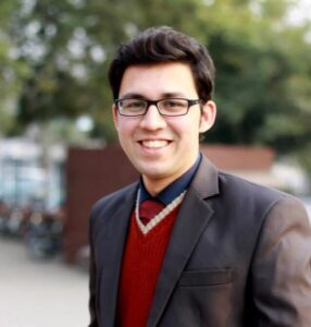 - Muhammad Shahzeb Image of dark-haired, smiling man wearing glasses and brown jacket.