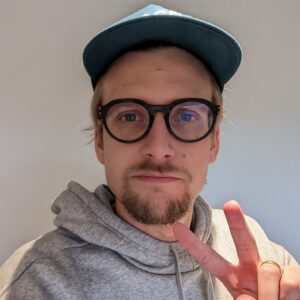 Profile pic for David Karlsson showing person in glasses and cap making peace sign
